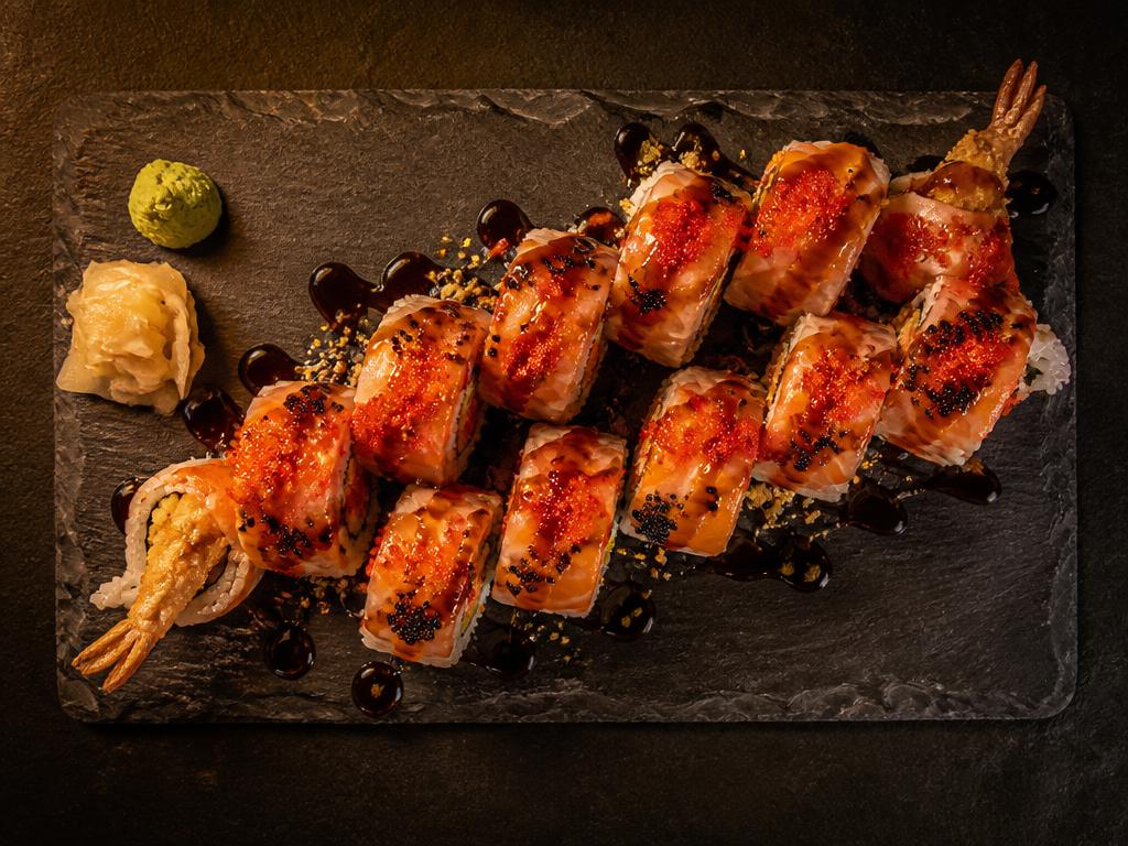 Mandarin roll topped with salmon, spicy crab and tobiko on dark slate